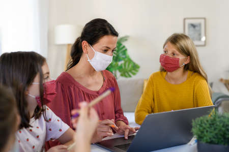 Group of homeschooling children with teacher studying indoors, coronavirus concept.