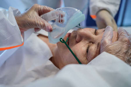 Close-up of covid-19 patient in bed in hospital, coronavirus and breathing problems concept.