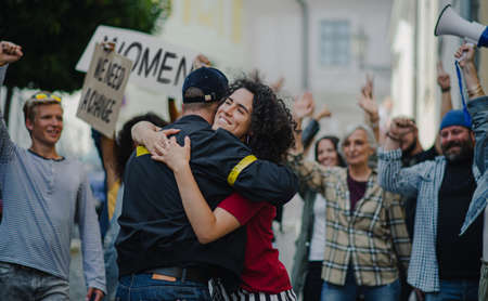 Police stopping group of people activists protesting on streets, women march and demonstration...
