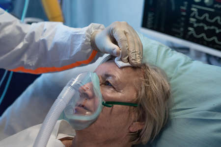 Close-up of covid-19 patient in bed in hospital, coronavirus and breathing problems concept.