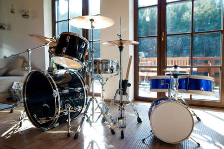 Set of drums indoors in living room in house, playing musical instrument concept.
