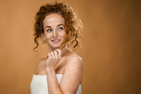 Topless young woman in a studio looking at camera, beauty concept.の写真素材