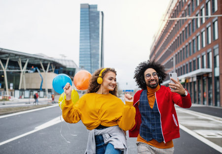 Young couple with smartphone making video outdoors on street