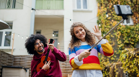 Young couple with smartphone making video outdoors on street