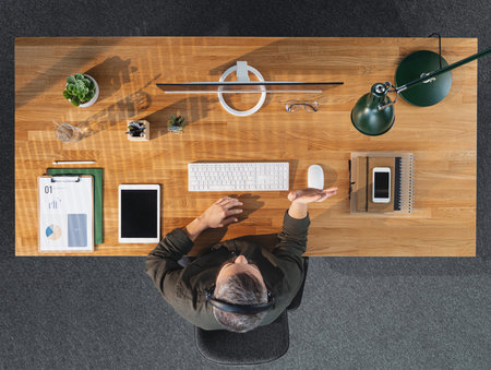 Top view of businessman working on computer at desk in home office, video call concept.の写真素材