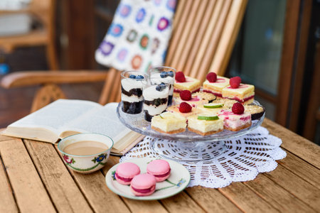 Cup of coffee and desserts on table outdoors on terrace.