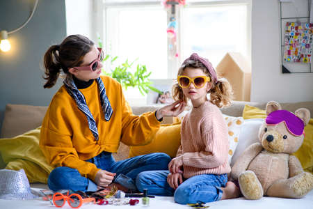 Sisters indoors at home, playing on bed. Lockdown concept.の写真素材