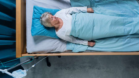 Top view of woman patient with iv drip in bed in hospital. Copy space.の写真素材