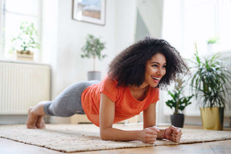 Young woman indoors at home, doing exercise. Sport concept.