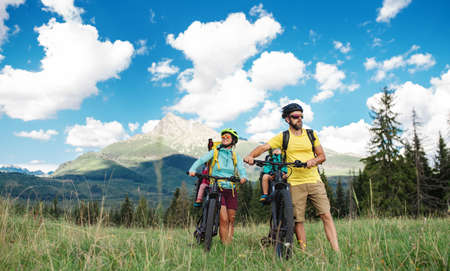 Family with small children cycling outdoors in summer nature, Tatra mountains Slovakia.の写真素材
