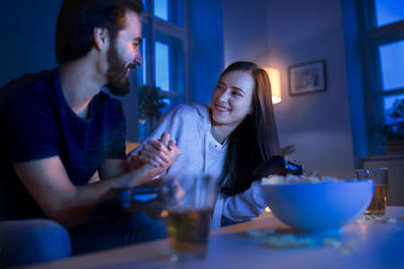 Young couple in love playing computer games indoors at home.の写真素材