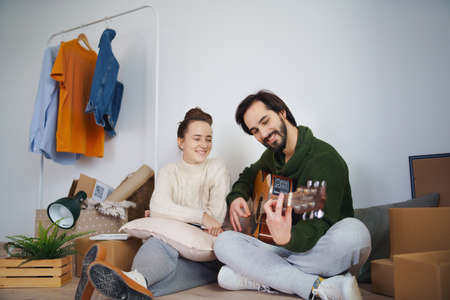Young couple with boxes and guitar moving in new flat, new home and relocation concept.の写真素材