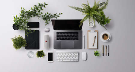 Flat lay top view office desk working space with laptop and supplies on gray background.の写真素材