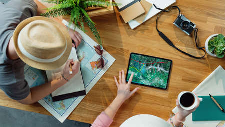 Top view of young couple with tablet planning vacation trip holiday, desktop travel concept.の写真素材