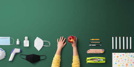Flat lay top view of face mask and school supplies, back to school and coronavirus concept.