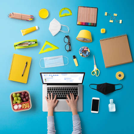 Flat lay top view of face mask and school supplies, distance learning and coronavirus concept.の写真素材