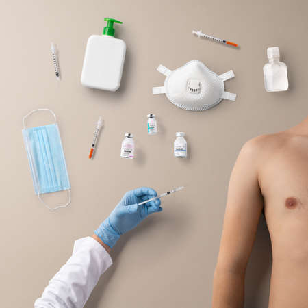 Hand with syringe injection and topless mans torso, covid-19 and vaccination concept.