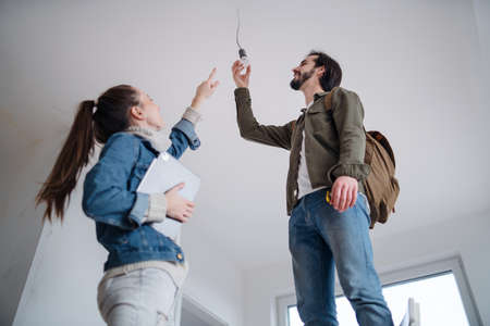 Low angle view of young couple moving and planning in new flat, new home and relocation concept.の写真素材