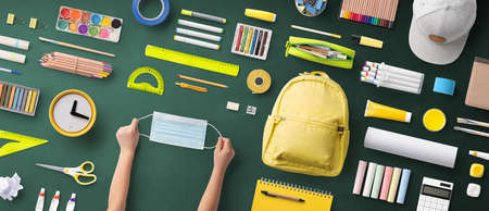 Flat lay top view of face mask and school supplies, back to school and concept.の写真素材