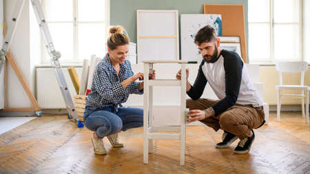 Mid adults couple renovating furniture indoors at home, relocation and diy concept.
