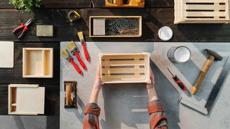 Top view of unrecognizable woman making wooden boxes, small business and desktop concept.の写真素材