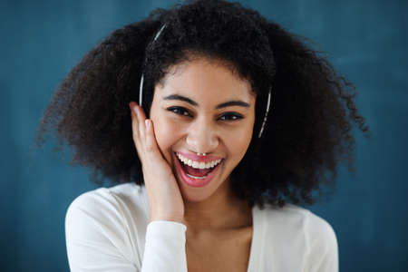 Close-up of young woman with headphones indoors at home, listening to music.の写真素材