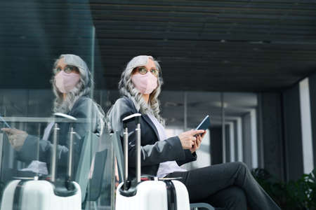 Senior woman in airport lounge, travel and new normal.の写真素材