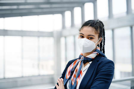 Young air hostess looking at camera in airport lounge,  travel and new normal.の写真素材