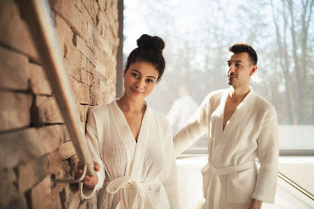 Portrait of young couple in spa resort, walking up the stairs.