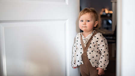 Portrait of small toddler girl in bedroom at home, looking at camera.の写真素材