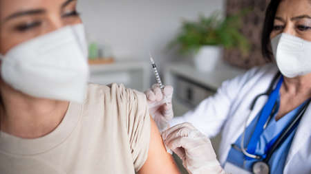 Woman with respirator getting vaccinated in hospital,  vaccination concept.