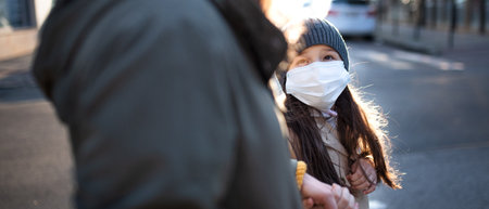 Unrecognizable mother with small daughter walking outdoors on street, coronavirus concept.の写真素材