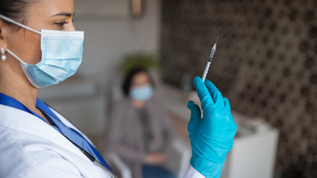 Portrait of woman doctor with syringe standing in hospital