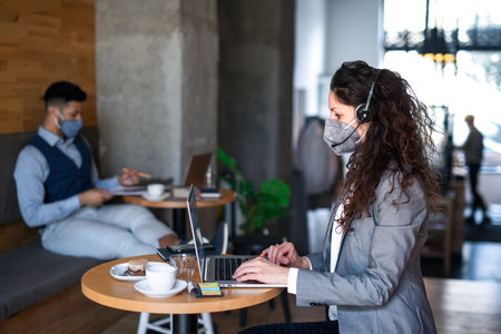 Business people with laptop working in cafe, small business, coronavirus and new normal concept.の写真素材