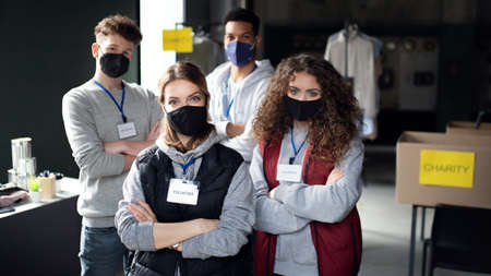 Group of volunteers working in community charity donation center, looking at camera.の写真素材