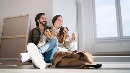 Young couple with keys moving in new flat, new home and relocation concept.の写真素材