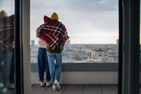 Rear view of young couple owners on balcony in new flat, moving in, new home and relocation concept.の写真素材