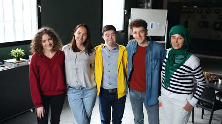 Down syndrome man with friends in community center, inclusivity and unity concept.の写真素材