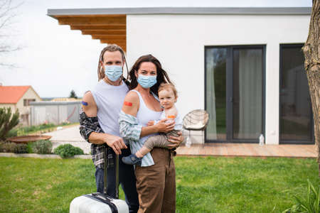 Portrait of young family with small baby after covid-9 vaccination, holiday and traveling concept.の写真素材