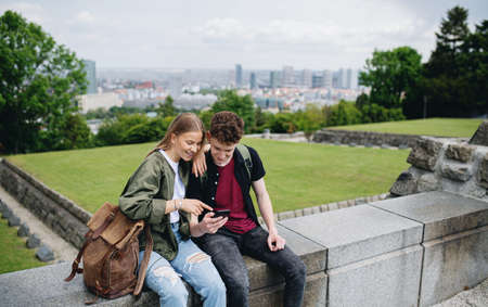 Young couple travelers in city on holiday, using smartphone.の写真素材