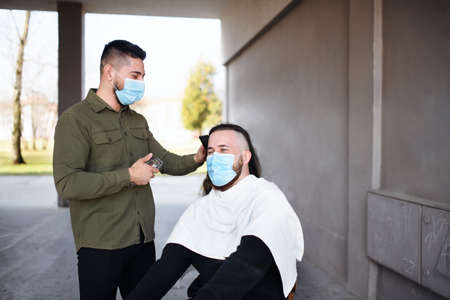 Haircut outdoors by block of flats in city,  lockdown concept.の写真素材