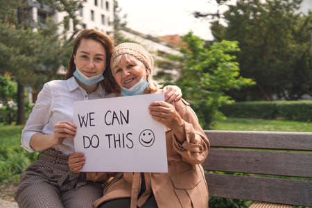 Portrait of young woman with grandmother outdoors in city, life after vaccination.の写真素材