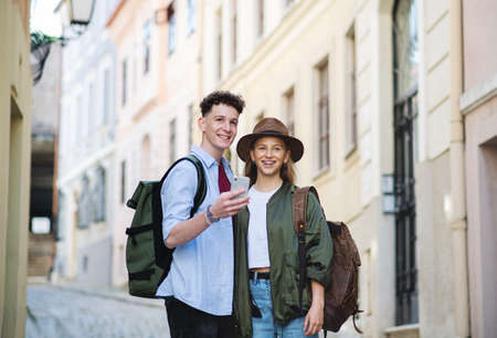 Young couple travelers using smartphone in city on holiday, sightseeing.
