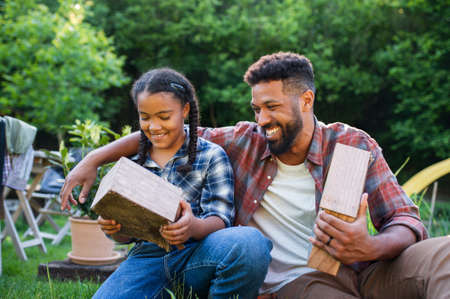 Happy young man with small sister spending time outdoors in backyard, laughing.の写真素材