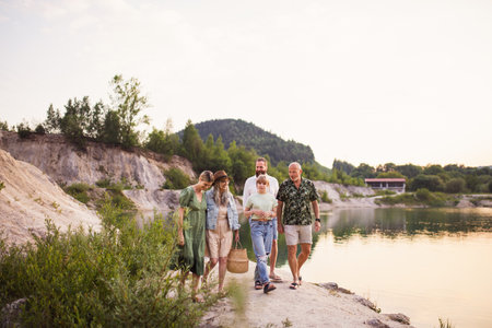 Happy multigeneration family on summer holiday, walking by lake.の写真素材