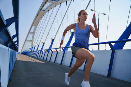Mid adult woman running outdoors in city, healthy lifestyle concept.の写真素材