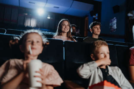 Cheerful young couple in the cinema, watching film.の写真素材