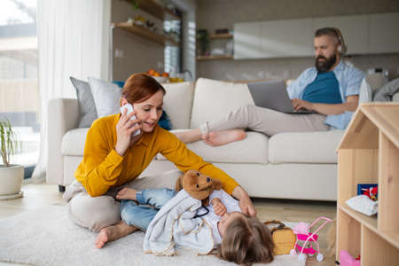 Mother with small daughter playing and working indoors at home, everyday life and home office with child concept.の写真素材