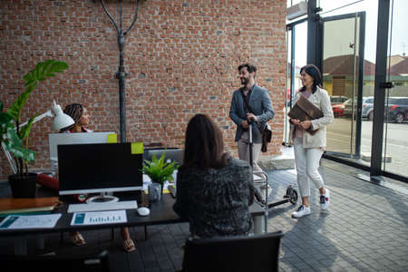 Young and old businesspeople working in office, coworking and eco commuting concept.の写真素材