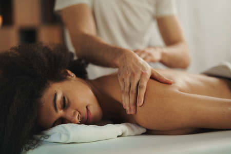 Young woman having back massage at the spa.
